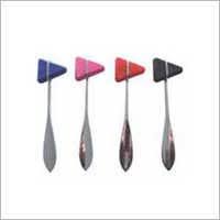 Four metal spoons with small colored flag tops (blue, pink, orange, black) arranged in a row on a white background